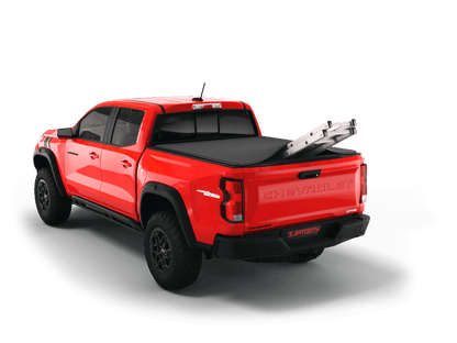 Red Chevrolet Colorado / GMC Canyon with ladder sticking out of Sawtooth Stretch expandable truck bed cover