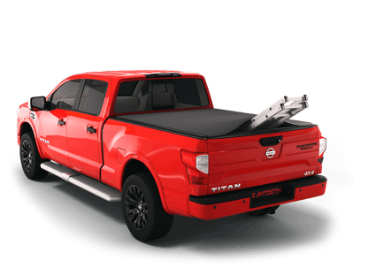 Red Nissan Titan with ladder sticking out of Sawtooth Stretch expandable truck bed cover