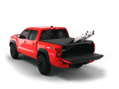 Red Nissan Frontier with Sawtooth Stretch expandable tonneau cover rolled up at cab