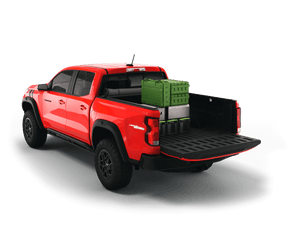 Red 2023 Chevrolet Colorado 5' 2" Bed / GMC Canyon 5' 2" Bed with gear in the truck bed and the Sawtooth Stretch tonneau cover rolled up at cab 