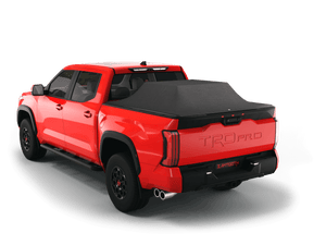 Red 2023 Toyota Tundra 5' 6" Bed with gear in the truck bed and the Sawtooth Stretch tonneau cover expanded over cargo load