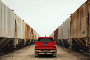 Red 2023 Ford Ranger 6' Bed with Sawtooth Stretch tonneau expanded over tall cargo load between trains