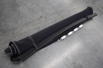 Black roll-up Sawtooth STRETCH truck bed cover on a gray concrete floor