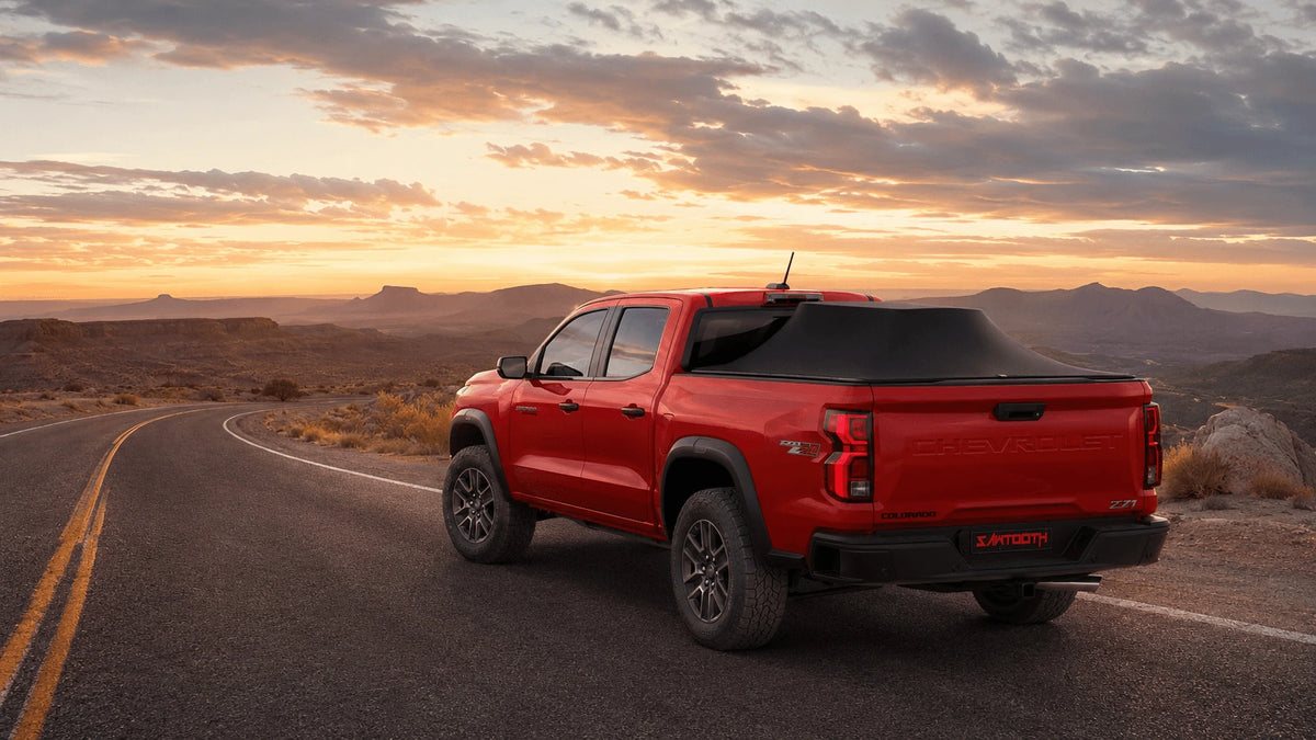 Red Chevrolet Colorado with Sawtooth STRETCH on a winding desert road at sunset