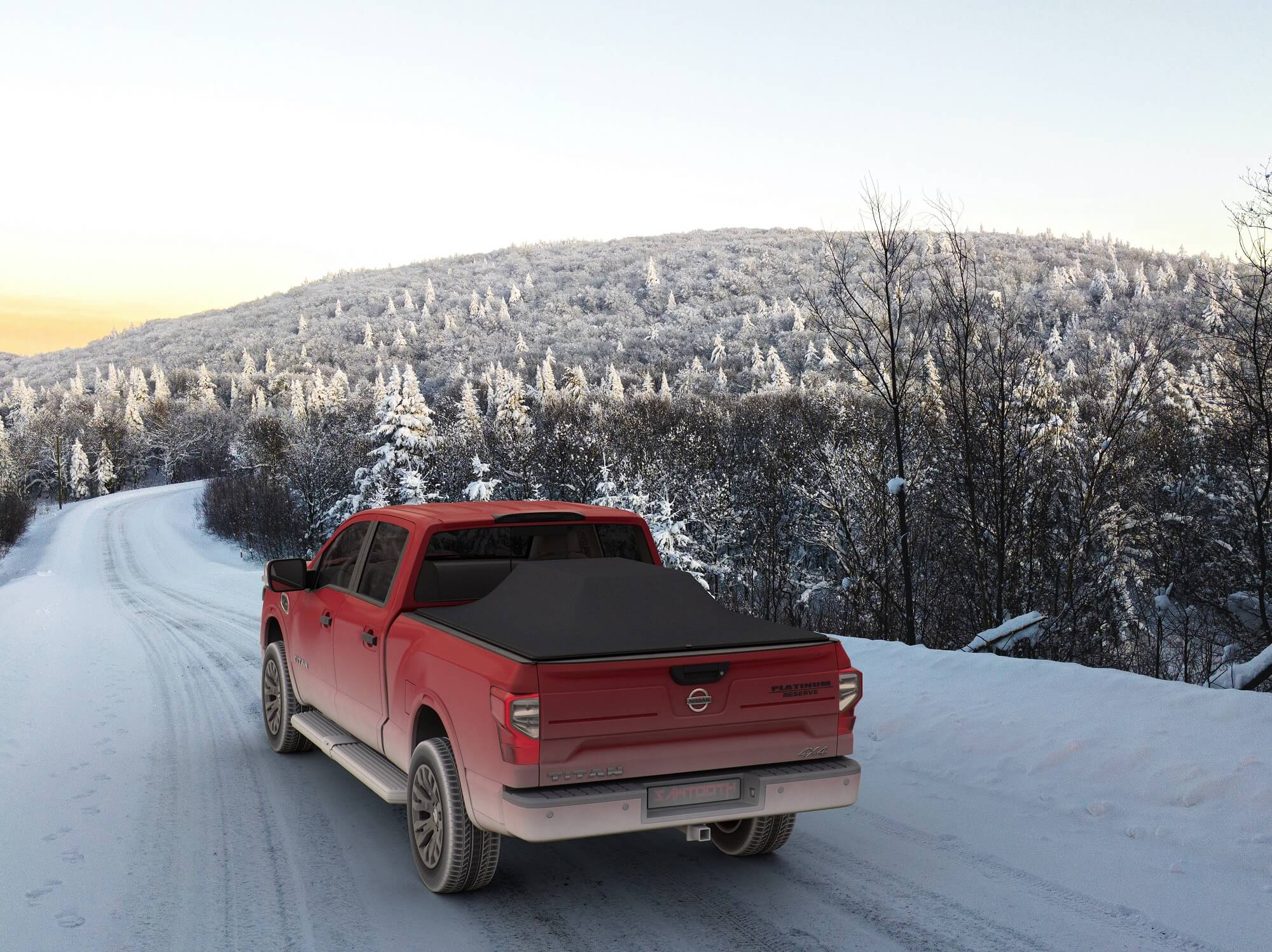 Red pickup truck with a black tonneau cover on a snowy road with snow-covered trees in the background.