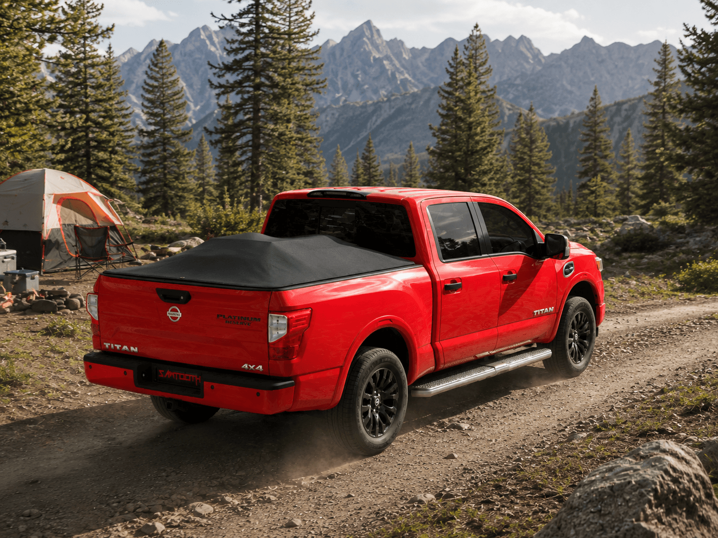 A red Nissan Titan pickup truck with a black soft top bed cover is shown from the rear three-quarter angle, driving on a dirt road in a mountain pine forest with a tent visible in the background.