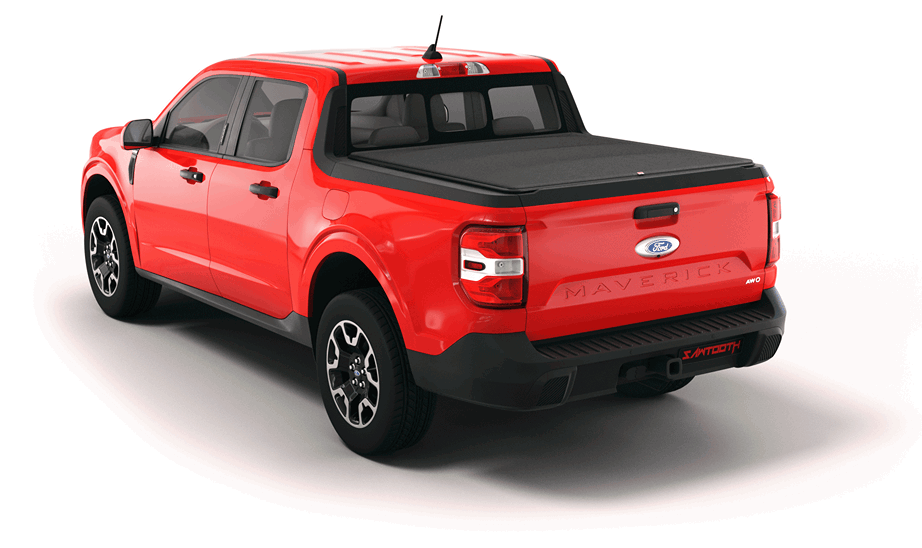 A red Ford pickup truck with a black tonneau cover is parked on a gravel road with a scenic backdrop of snow-capped mountains and a blue sky.