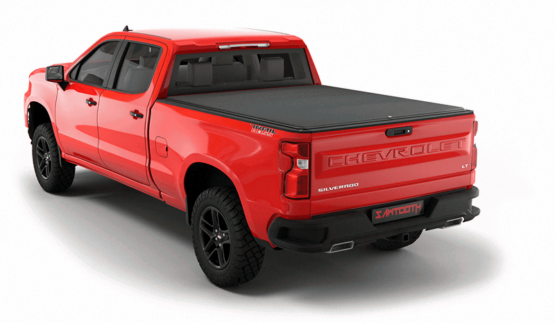 Red Chevrolet Silverado pickup truck with green storage case in the truck bed