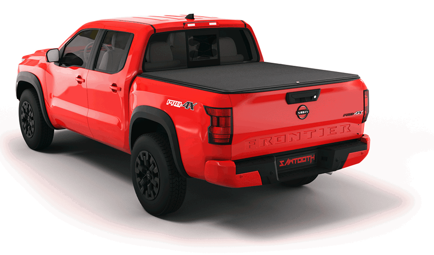 Red Nissan Frontier pickup truck with black tonneau bed cover, rear three-quarter view