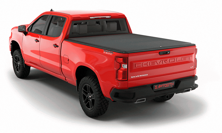Red pickup truck with open tailgate carrying green storage cases and cargo boxes in the truck bed