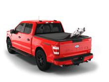 Load image into Gallery viewer, Red 2024 Ford F-150 6&#39; 7&quot; Bed with ladder sticking out of Sawtooth Stretch expandable truck bed cover
