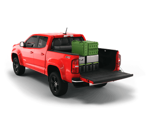 Red 2021 Chevrolet Colorado 5' 2" Bed / GMC Canyon 5' 2" Bed with gear in the truck bed and the Sawtooth Stretch tonneau cover rolled up at cab 
