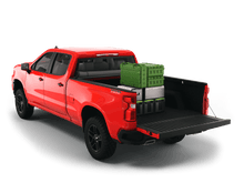 Load image into Gallery viewer, Red 2021 Chevrolet Silverado 2500 3500 6&#39;-9&quot; bed / GMC Sierra 2500 3500 6&#39;-9&quot; bed with gear in the truck bed and the Sawtooth Stretch tonneau cover rolled up at cab 
