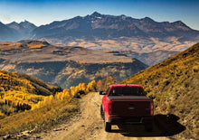 Load image into Gallery viewer, Red 2019 Ford Ranger with Sawtooth Stretch tonneau expanded over tall cargo load with distant rugged mountains
