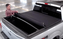 Load image into Gallery viewer, Rolling up Sawtooth Stretch expandable tonneau cover on a 2020 Chevrolet Silverado 2500 3500 6&#39;-9&quot; bed / GMC Sierra 2500 3500 6&#39;-9&quot; Bed
